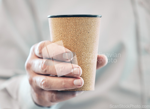 Image of The fuel for success. an unrecognizable businessman holding a takeaway coffee while standing in his office.