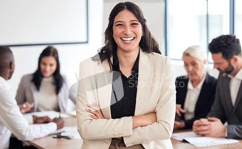 Image of Our meetings always go well. a young businesswoman standing with her arms crossed during a meeting at work.