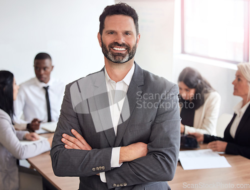 Image of Hes got this covered. a mature businessman standing with his arms crossed during a meeting at work.