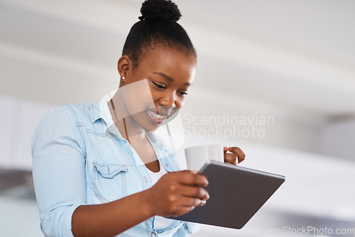 Image of Im definitely sharing this post. a woman drinking coffee while using a digital tablet at home.