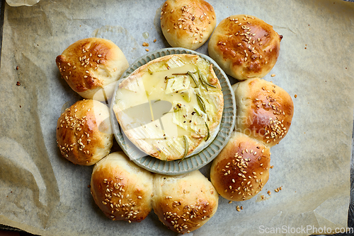 Image of closeup of freshly baked bread buns with melted brie