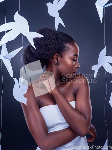 Image of You wont know beauty into you discover freedom. Studio shot of a beautiful young woman posing with paper birds against a black background.