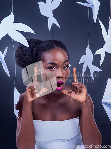 Image of You dont need any reason to shine - shine for yourself. Studio portrait of a beautiful young woman posing with paper birds against a black background.