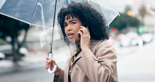 Image of Businesswoman, worry and phone for talking in city for commute to work by walking with umbrella for rain. African person, manager and serious face while late for career, job or meeting with client