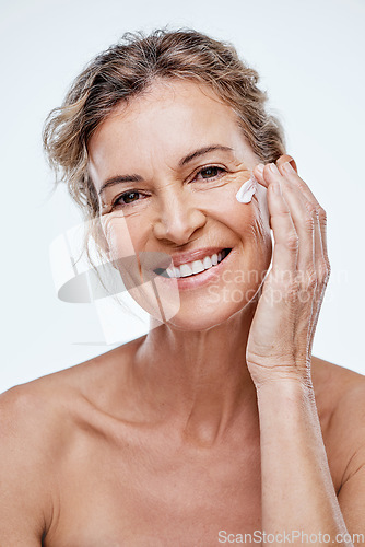 Image of A good skincare routine is a must at any age. a mature woman posing with moisturiser on her face.