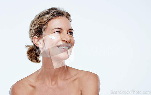 Image of People think Im lying when I share my age. a mature woman posing with moisturiser on her face.