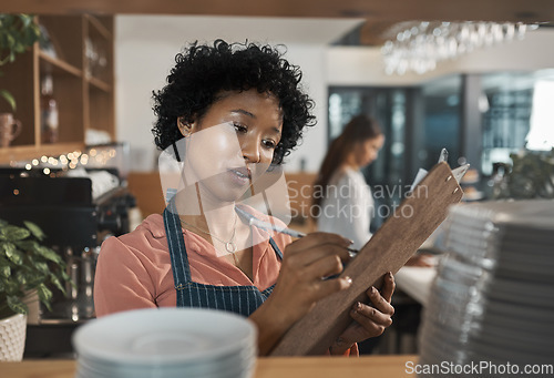 Image of You have what it takes to make a success of anything. a woman making notes on her clipboard while working in a cafe.