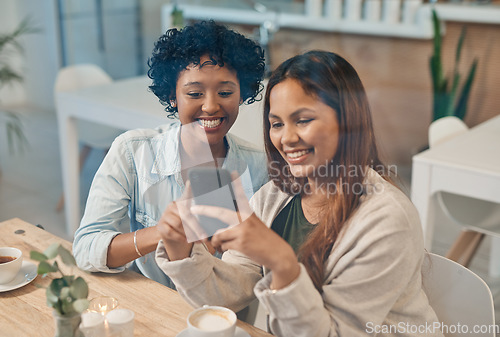 Image of We cant be there for everything but we can share the memories. two friends looking at something on a cellphone while sitting together in a coffee shop.