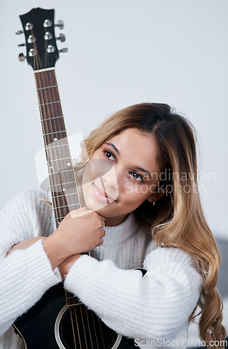 Image of I have a passion for music. a young woman sitting at home with her guitar.