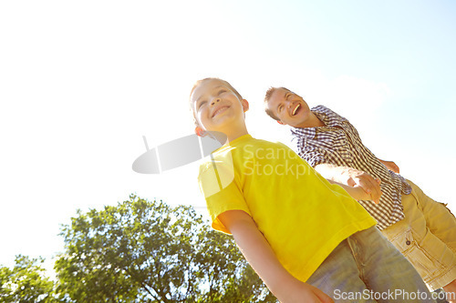 Image of Whats over there, dad. Cute young boy smiling widely outdoors with his dad.