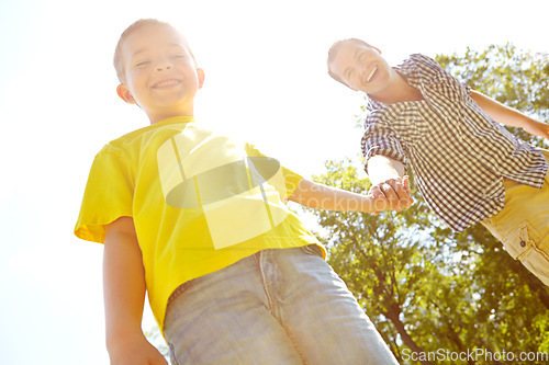 Image of Special father-son moments. Young father and his son spending time outdoors while smiling widely.