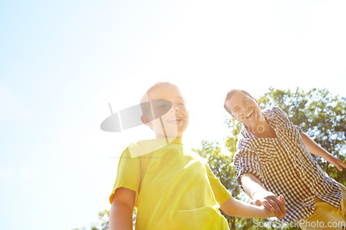 Image of Look at this. Cute young boy pulling his dad by the hand to show him something outdoors.