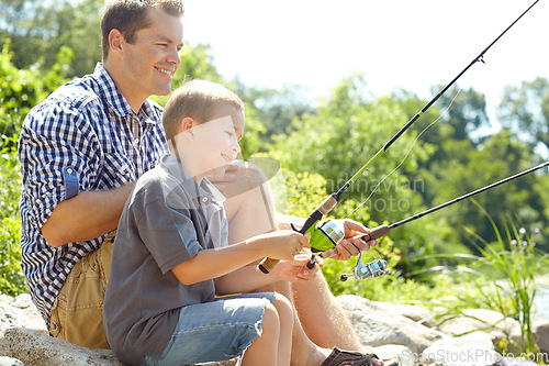 Image of Fishing in the sunshine with dad. Side view of a father sitting and fishing with his son.