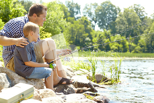 Image of Relaxing beside the lake with my son. Young father sitting beside his son and fishing.