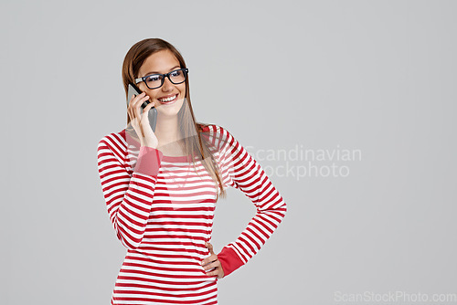 Image of Ill be there. Studio shot of an attractive young woman using a smartphone on a grey background.