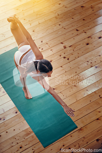 Image of Yoga gives her body a full workout. High angle shot of a young woman doing yoga indoors.