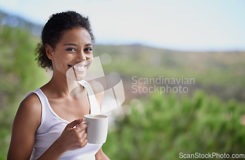 Image of Her morning drink always brightens up her day. Portrait of a young woman enjoying a cup of coffee.