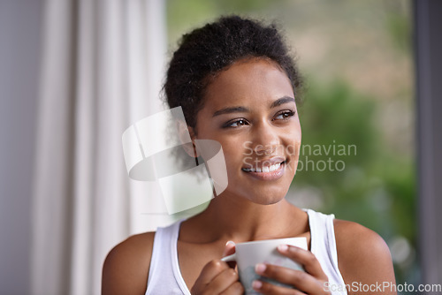 Image of Enjoying the sights and smells of an early morning. a young woman enjoying a cup of coffee.