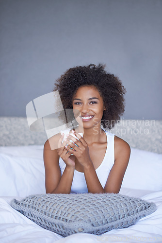 Image of Theres nothing like waking up with coffee in your cup. a young woman enjoying a cup of coffee while lying on bed.