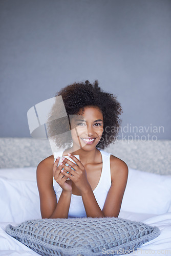 Image of Nothing beats starting your day with coffee. a young woman enjoying a cup of coffee while lying on bed.