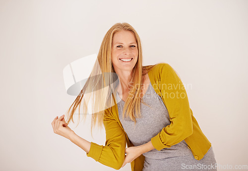 Image of That shampoo made my hair feel great. Portrait of a happy woman leaning over while playing with her hair.