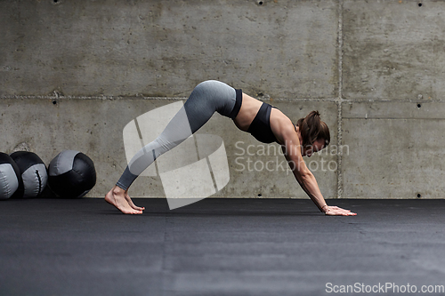 Image of Fit woman in a modern gym working flexibility and strength through various exercises, demonstrating her commitment to fitness