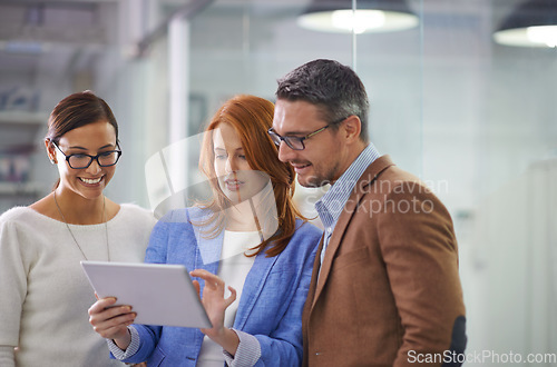 Image of What do you think. three businesspeople working on a digital tablet.