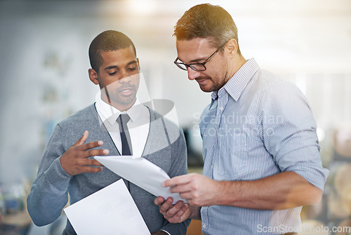 Image of Sharing his ideas. two businessmen discussing paperwork.