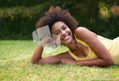 Image of Having a happy day in the sun. Portrait of a happy young woman lying on the grass.