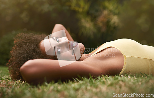 Image of Just chillin. Portrait of a happy young woman lying on the grass.