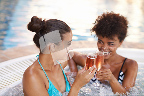 Image of Sharing a luxurious experience with my best friend. two gorgeous young women enjoying a glass of champagne in a jacuzzi.