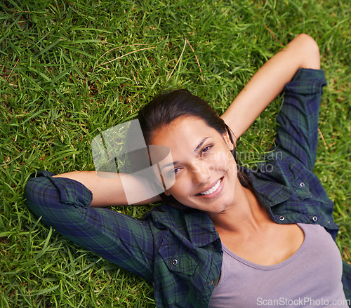 Image of Soaking up the tranquility. High angle portrait of an attractive young woman lying on the grass.