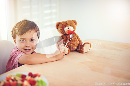 Image of Teddy should be healthy too. A little boy feeding fruit to a teddy.