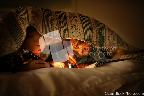 Image of Bonding under their blankets. Two young brothers coloring in pictures while underneath their blanket after their bedtime.