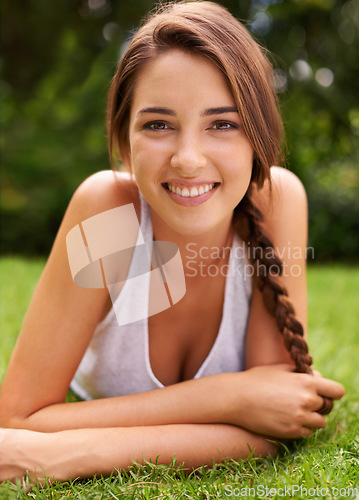 Image of She just loves being outdoors. Portrait of an attractive young woman lying on the grass.