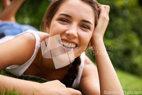 Image of She just loves being outdoors. Portrait of an attractive young woman lying on the grass.