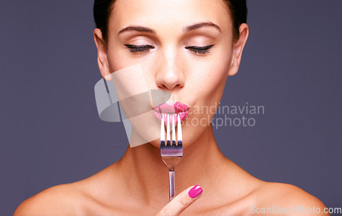 Image of Shes as classy as the silverware. a beautiful young woman biting on a fork.