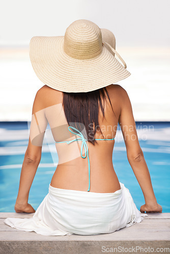 Image of Shes got the look of summer. Rear view shot of a young woman relaxing by a swimming pool.