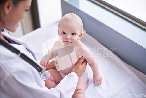 Image of Having his very first checkup. a female doctor doing a checkup of a baby.