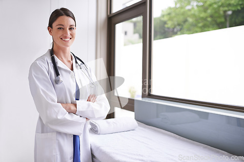 Image of Her expertise keeps your health sound. A smiling young doctor standing in a clinic.