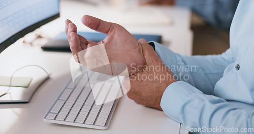 Image of Businessman, hands and wrist in joint pain from injury, overworked or carpal tunnel syndrome at office. Closeup of man or employee with arthritis, ache or inflammation of palm on desk at workplace