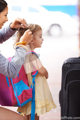 Image of Daughter are little girls that grow up to become your friend. A mother tying her daughters hair while waiting for their transport to arrive.