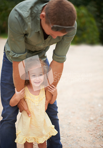 Image of Anyone can be a father only someone special can be a Dad. A father holding on to his adorable little girl as they stand outdoors.