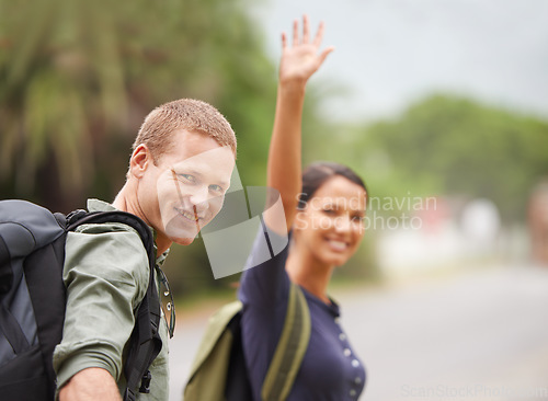 Image of Taxi please. A cute couple calls a cab as they stand on the side of a road.