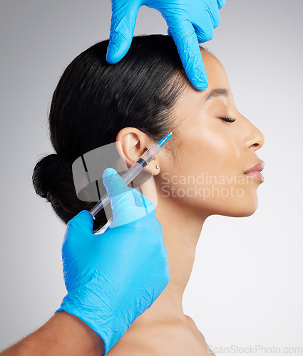 Image of Closeup of a gorgeous mixed race woman getting botox filler. Hispanic model getting filler to reduce wrinkles against a grey copyspace background in a studio