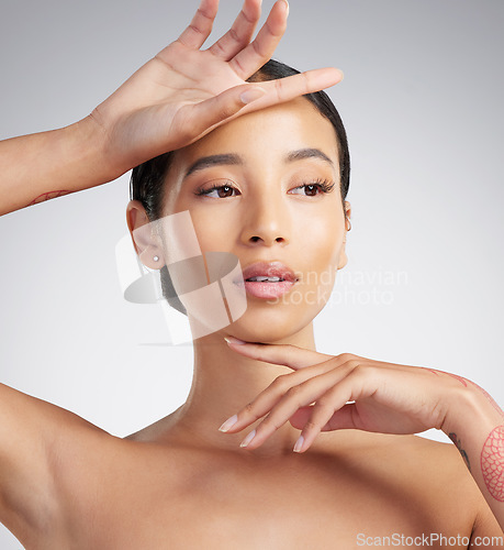 Image of A beautiful young mixed race woman with glowing skin posing against grey copyspace background. Young confident woman doing a routine selfcare grooming routine with glowing radiant skin