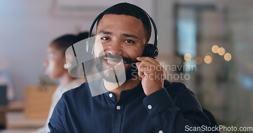 Image of Portrait, smile and man at call center on headphones for crm support on bokeh at night. Face, happy sales agent on mic and telemarketing consultant, customer service professional or worker in office