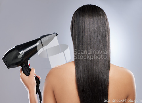 Image of Time to get a blowout. Rearview shot of a woman with sleek hair holding a hairdryer.