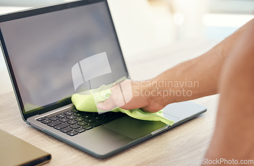 Image of Keeping the germs away. an unrecognizable person cleaning their workspace in an office.