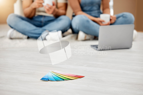 Image of Everything is about colour. Closeup shot of colour swatches on the floor with an unrecognisable couple using a laptop in the background while moving house.